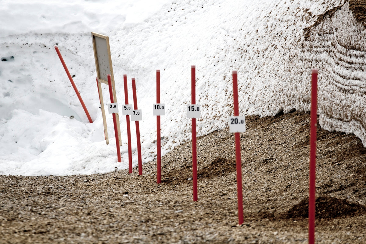 white and red wooden poles on white sand during daytime