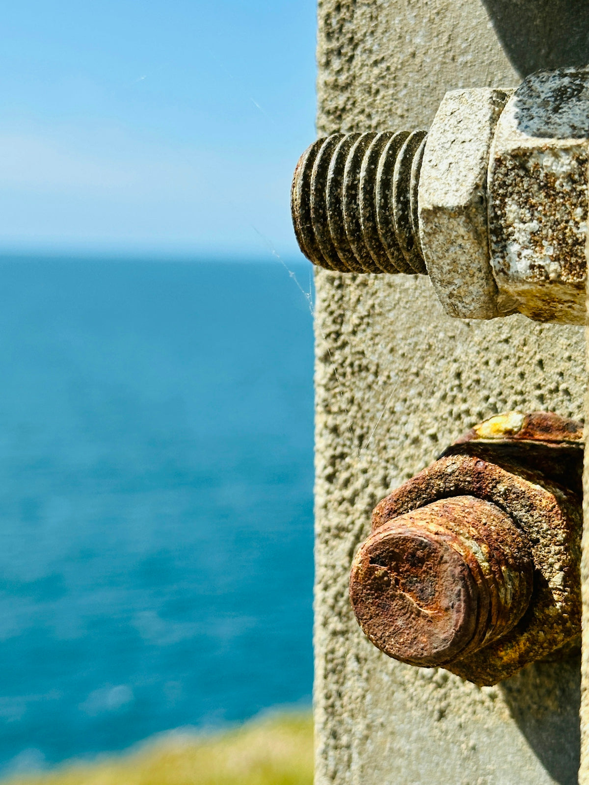 Rusty bolts and a blue sea.