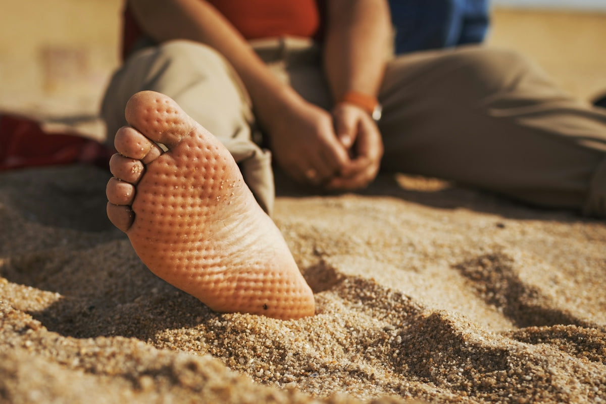 Close-up of a person's bare foot on sand