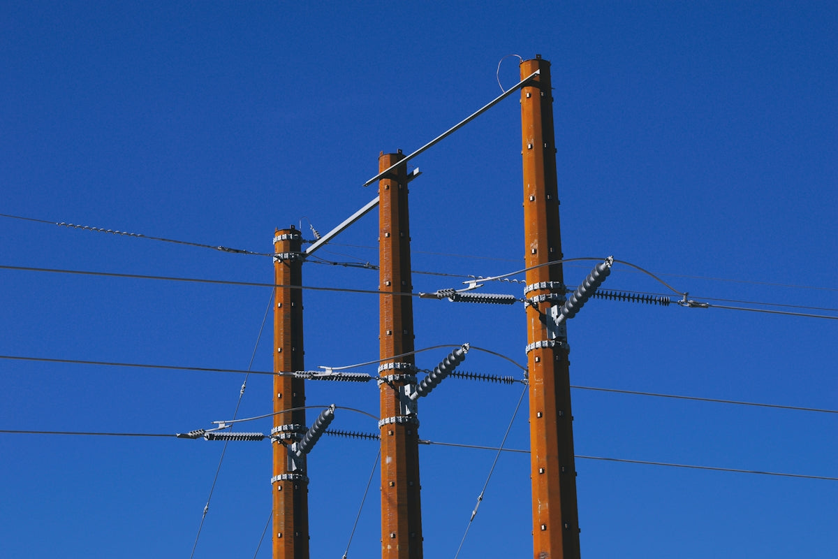 Wooden power poles against a clear blue sky