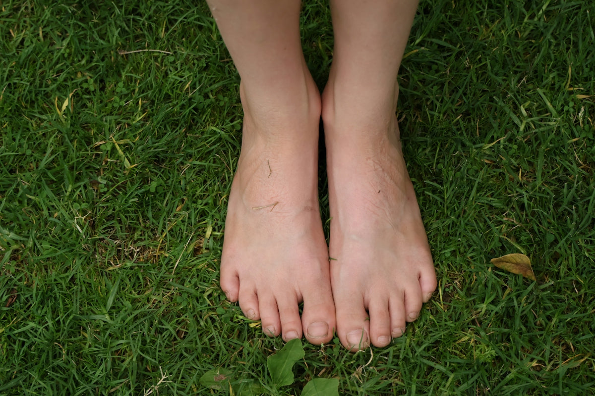 Bare feet standing on green grass
