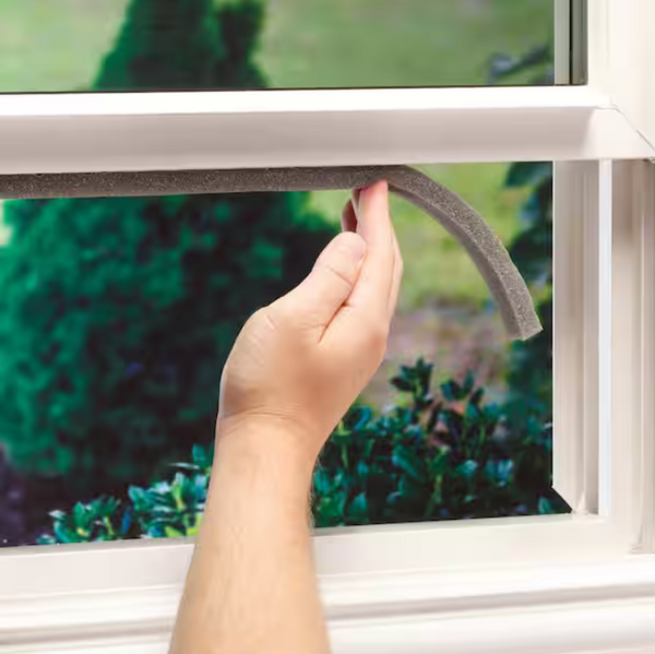 Hand applying Rod Foam Installation on Window